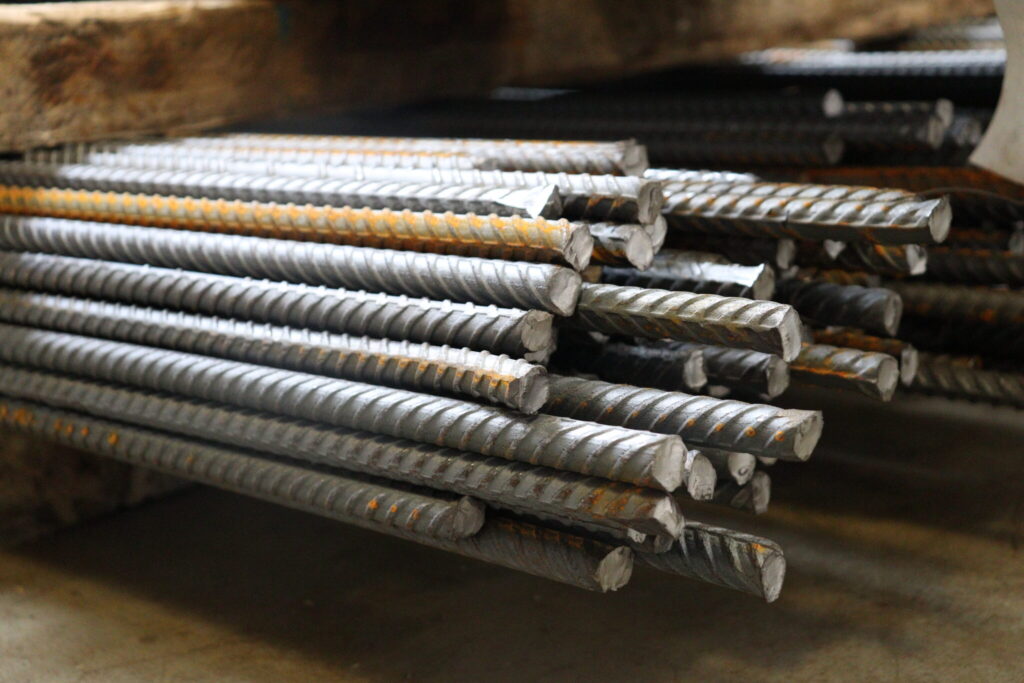 Worker handling fabricated 400W reinforcing steel rebar bundles